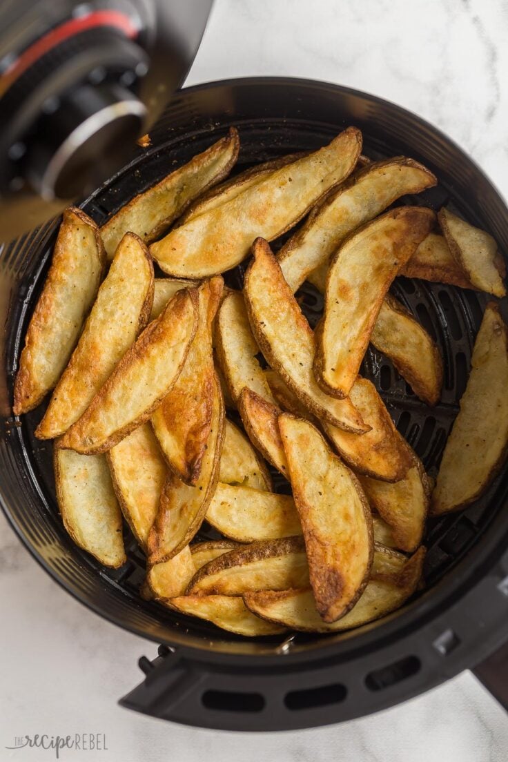 overhead image of air fryer potato wedges in air fryer basket