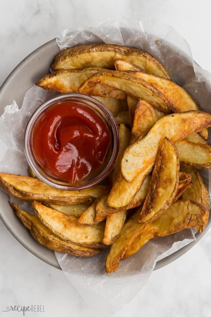 bowl of crispy potato wedges with small bowl of ketchup