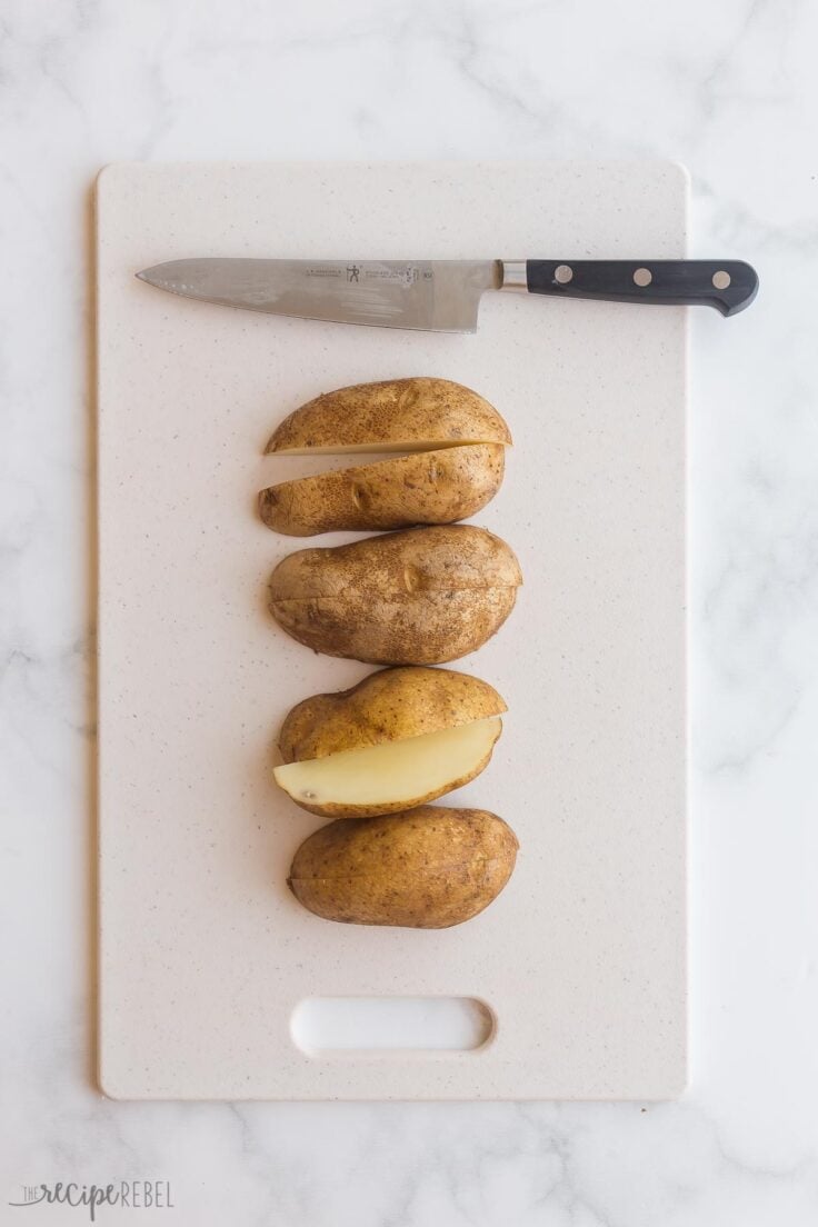 cutting russet potatoes in quarters on cutting board