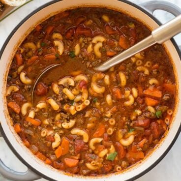 overhead image of macaroni soup with ladle stuck in