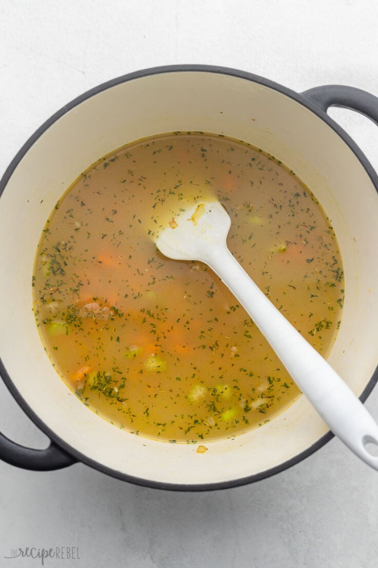 broth, vegetables and a spatula in large pot.