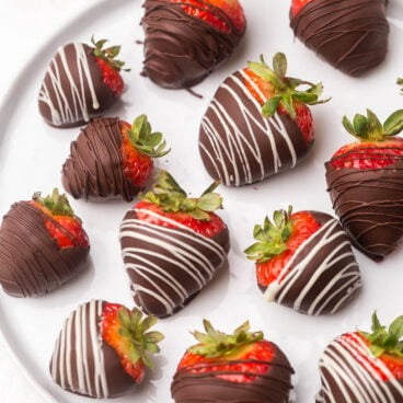 Top view of a plate full of chocolate covered strawberries.