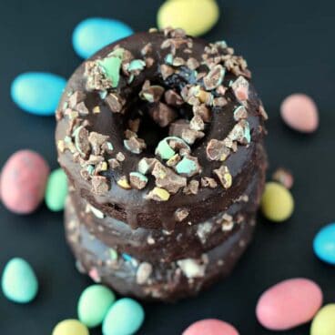 Double Chocolate Easter Candy Doughnuts: because chocolate on chocolate on chocolate is a good thing. Perfectly fudgy doughnuts with chocolate glaze and crushed Easter chocolates! www.thereciperebel.com