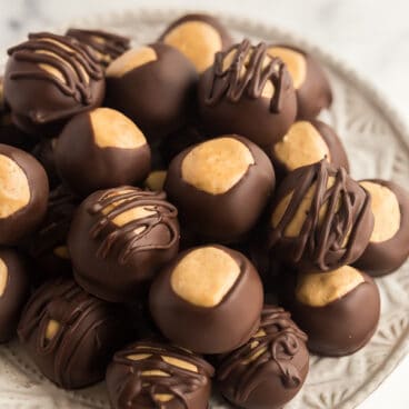 chocolate peanut butter balls stacked on white plate