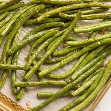 close up image of roasted green beans on baking sheet